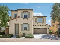 Charming two-story home featuring a tile roof, tan siding, and a two-car garage at 8341 Lower Trailhead Ave, Las Vegas, NV 89113