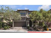Charming two-story home showcasing a well-manicured yard with mature trees, a neutral color palette, and an attached two-car garage at 9950 Coyote Echo Ct, Las Vegas, NV 89166