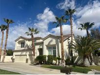Inviting two-story home with a well-manicured lawn and mature palm trees at 10 Gulf Pines Ave, Las Vegas, NV 89148