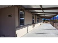Spacious home exterior with covered porch, desert views, and ample natural light through multiple windows at 1180 Lava Ave, Jean, NV 89019