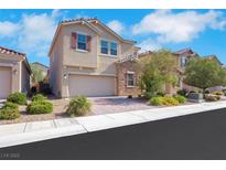 Charming two-story home featuring a brick driveway, stucco exterior, well-manicured landscaping, and an attached two-car garage at 152 Walkinshaw Ave, Las Vegas, NV 89148