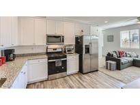 Modern kitchen features white cabinets, granite countertops, and stainless steel appliances at 1611 Prairie Fields Ct, Las Vegas, NV 89115