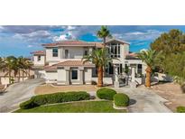 Stunning two-story home boasting a red tile roof, a large front lawn, palm trees, and a circular driveway at 2058 Troon Dr, Henderson, NV 89074