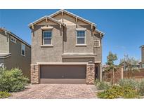 Two-story home featuring a brick-paved driveway and a two-car garage with stone accents at 363 Silva Pl, Henderson, NV 89011