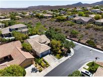 Expansive aerial view of a charming community with lush landscaping and mountain views at 42 Glade Water Dr, Henderson, NV 89052