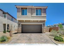 Two story home with a brick driveway, a two car garage and neutral colored stucco at 4240 Spring Storm Ave, North Las Vegas, NV 89081