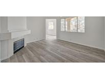 Bright living room featuring wood-look floors, fireplace, and large windows offering natural light at 5155 W Tropicana Ave # 2095, Las Vegas, NV 89103