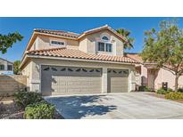 Charming two-story home featuring a three-car garage, tile roof, and well-maintained landscaping at 697 Gull Point Ave, Las Vegas, NV 89123