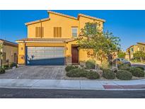 Charming two-story home featuring a tile roof, two-car garage, and desert landscaping under a clear blue sky at 7702 Wishbone Falls St, North Las Vegas, NV 89084