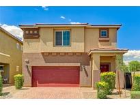 Charming two-story home with a red garage door, neat landscaping, and a brick driveway at 934 Twincrest Ave, North Las Vegas, NV 89032