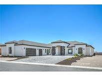 Stunning single-story home featuring a modern design, three-car garage, and beautiful desert landscaping at 1525 Heights Dr, Logandale, NV 89021
