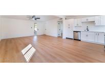 Bright, open living room features wood-look floors, ceiling fan, and modern white cabinets at 2878 El Cajon St, Las Vegas, NV 89169