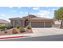Charming single-story home with a three-car garage and desert landscaping under a blue sky at 3088 Evening Mist Ave, Henderson, NV 89052