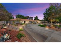 Stunning exterior view of a single-story home with a circular driveway and vibrant, low-maintenance landscaping at 3108 Sonia Dr, Las Vegas, NV 89107