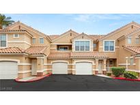 Beige stucco townhomes with red tile roofs and attached garages offer convenient parking at 5855 Valley Dr # 1080, North Las Vegas, NV 89031
