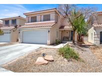 Two-story home featuring a red tile roof, two-car garage, and desert landscaping at 7437 Treasure Chest St, Las Vegas, NV 89139