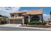 Two-story home with a tile roof, a three-car garage, and mature landscaping at 8820 Fall Green Ave, Las Vegas, NV 89129