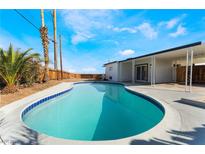 Inviting pool with blue trim, surrounded by landscaping and a covered patio, perfect for outdoor relaxation at 2 Utah Way, Henderson, NV 89015