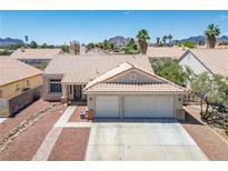 Charming single-story home with a two-car garage, desert landscaping, and a red tile roof at 218 Red Coral Dr, Henderson, NV 89002