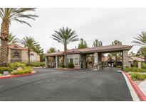 Gated entrance to the community with lush landscaping and mature palm trees on a cloudy day at 2200 S Fort Apache Rd # 2217, Las Vegas, NV 89117
