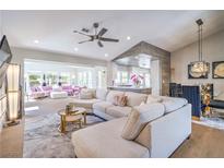 Bright, open-concept living room featuring a modern ceiling fan, plush sectional sofa, and an adjacent sitting area at 3101 Hayden Ct, Las Vegas, NV 89134