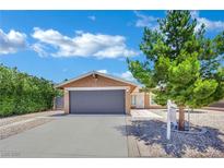 Charming single-story home featuring a two-car garage, landscaped yard, and desert rock at 317 Kane Ave, Las Vegas, NV 89110
