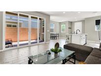 Bright living room with modern gray interior, tile floors, and large sliding glass doors to the exterior at 4533 Queens Hill St, North Las Vegas, NV 89031