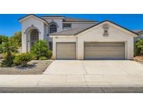 Two-story home featuring a stucco exterior, tile roof, and a two-car garage at 5409 Flora Spray St, Las Vegas, NV 89130