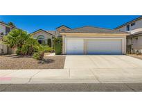 Charming single-story home featuring a spacious driveway leading to a two-car garage and desert landscaping at 5413 Flora Spray St, Las Vegas, NV 89130