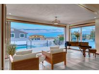 Bright living room with a piano and expansive windows that offer panoramic views of the neighborhood and a pool at 5438 Sierra Brook Ct, Las Vegas, NV 89149