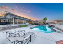 Stunning backyard pool with modern lounge chairs and adjacent covered patio, perfect for outdoor relaxation and entertaining at 5438 Sierra Brook Ct, Las Vegas, NV 89149