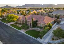 Stunning aerial view of custom home featuring tile roof, lush landscaping, and mountain views at 6120 Kings Brook Ct, Las Vegas, NV 89149