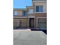 Inviting townhome exterior with a private garage and stone accents around the front door at 656 Peachy Canyon Cir # 203, Las Vegas, NV 89144