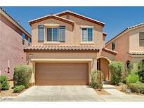 Two-story home with a two-car garage, desert landscaping, and a tile roof exudes curb appeal at 7704 Lots Hills Dr, Las Vegas, NV 89179