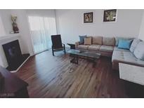Bright living room with hardwood floors, fireplace, modern sofa, and sliding glass door at 9000 Las Vegas Blvd # 1037, Las Vegas, NV 89123