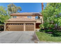 Charming two-story home featuring a three-car garage, well-manicured lawn, and beautiful desert landscaping at 902 Cripple Creek Ct, Henderson, NV 89014