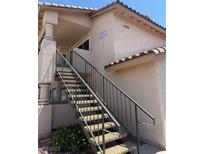 Charming condo exterior featuring stairs leading up to the entrance with neutral stucco and dark railings at 1320 Driscoll Dr # 201, Las Vegas, NV 89128
