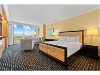 Comfortable bedroom with a king bed, sitting area, and expansive windows offering stunning city views at 2000 N Fashion Show Dr # 4318, Las Vegas, NV 89109