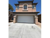 Beige two-story home featuring an attached two-car garage and well-maintained front yard at 5316 Fireside Ranch Ave, Las Vegas, NV 89131