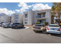 Condo exterior with multiple resident parking spaces available and beautiful landscaping at 6800 E Lake Mead Blvd # 2076, Las Vegas, NV 89156
