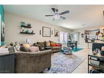 Cozy living room featuring comfortable seating, stylish decor, and a modern ceiling fan with a crystal light fixture at 7717 Pine Warbler Way, North Las Vegas, NV 89084