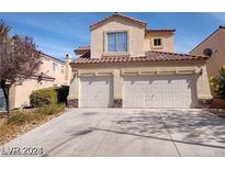 Two-story home featuring a two-car garage, tan stucco exterior, and a well-maintained driveway in a suburban neighborhood at 256 Camino Viejo St, Henderson, NV 89012