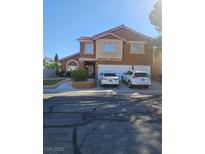 Two-story house with neutral tones, red roof, three-car garage, and desert landscaping at 2913 Domino Way, Las Vegas, NV 89117