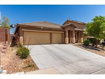 Charming single-story home featuring a desert landscape, wide driveway, and an attached two-car garage at 312 Purple Passion Ave, North Las Vegas, NV 89032