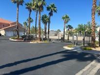 Gated community entrance with mature palm trees in a sunny neighborhood at 3327 Erva St # 222, Las Vegas, NV 89117