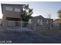 View of two-story home featuring neutral paint, fenced yard and gated entry at 3439 Cox St, North Las Vegas, NV 89032