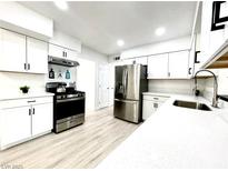 Modern kitchen featuring white cabinets, stainless steel appliances, and light wood flooring at 4324 El Conlon Ave, Las Vegas, NV 89102