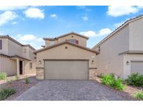 Two-story home featuring a two car garage and desert landscaping for low maintenance living at 5677 Asyma Ct, Las Vegas, NV 89113