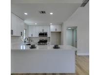 Bright kitchen features white cabinetry, stainless steel appliances, and a large island with a white countertop at 5742 Forsythe Dr, Las Vegas, NV 89142
