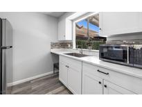 Bright kitchen features white cabinets, stainless steel appliances, and a large window at 6442 Ironbark Ln, Las Vegas, NV 89107